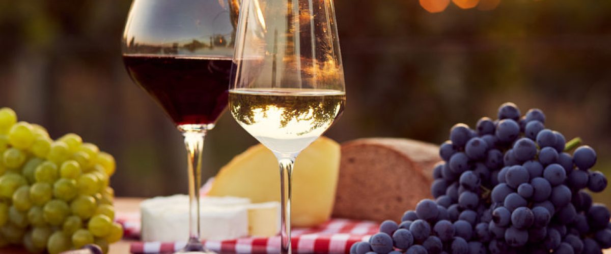 45249669 - two glasses of white and red wine with food at sunset, toned